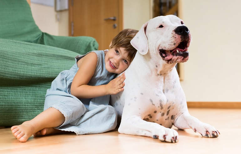 Kleines Mädchen umarmt Hund